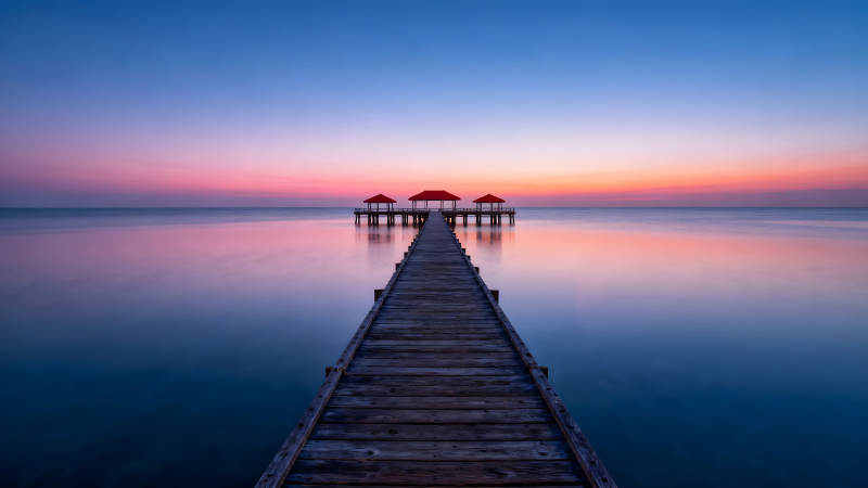 海边长廊日出景象天空被色彩晕染-图片