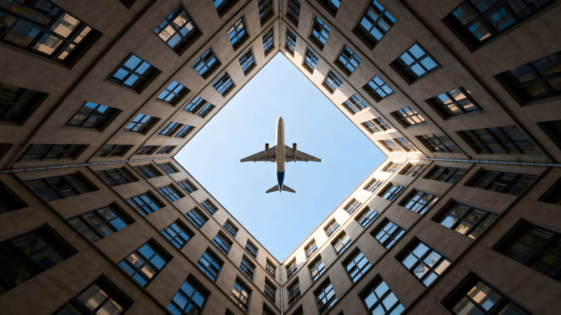 飛機穿過建筑物的方形天空-圖片