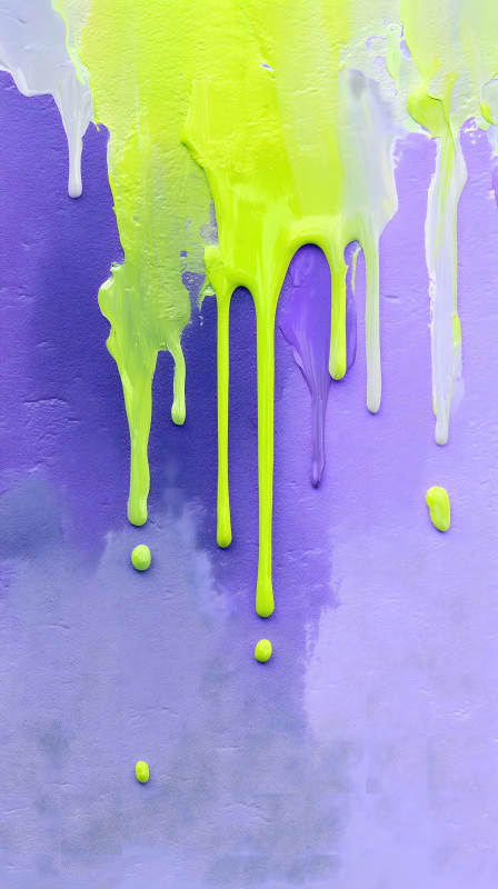 抽象滴落的荧光颜料在紫色背景上图片
