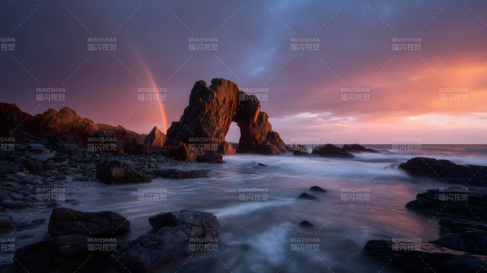 彩虹下的海边岩石拱门图片