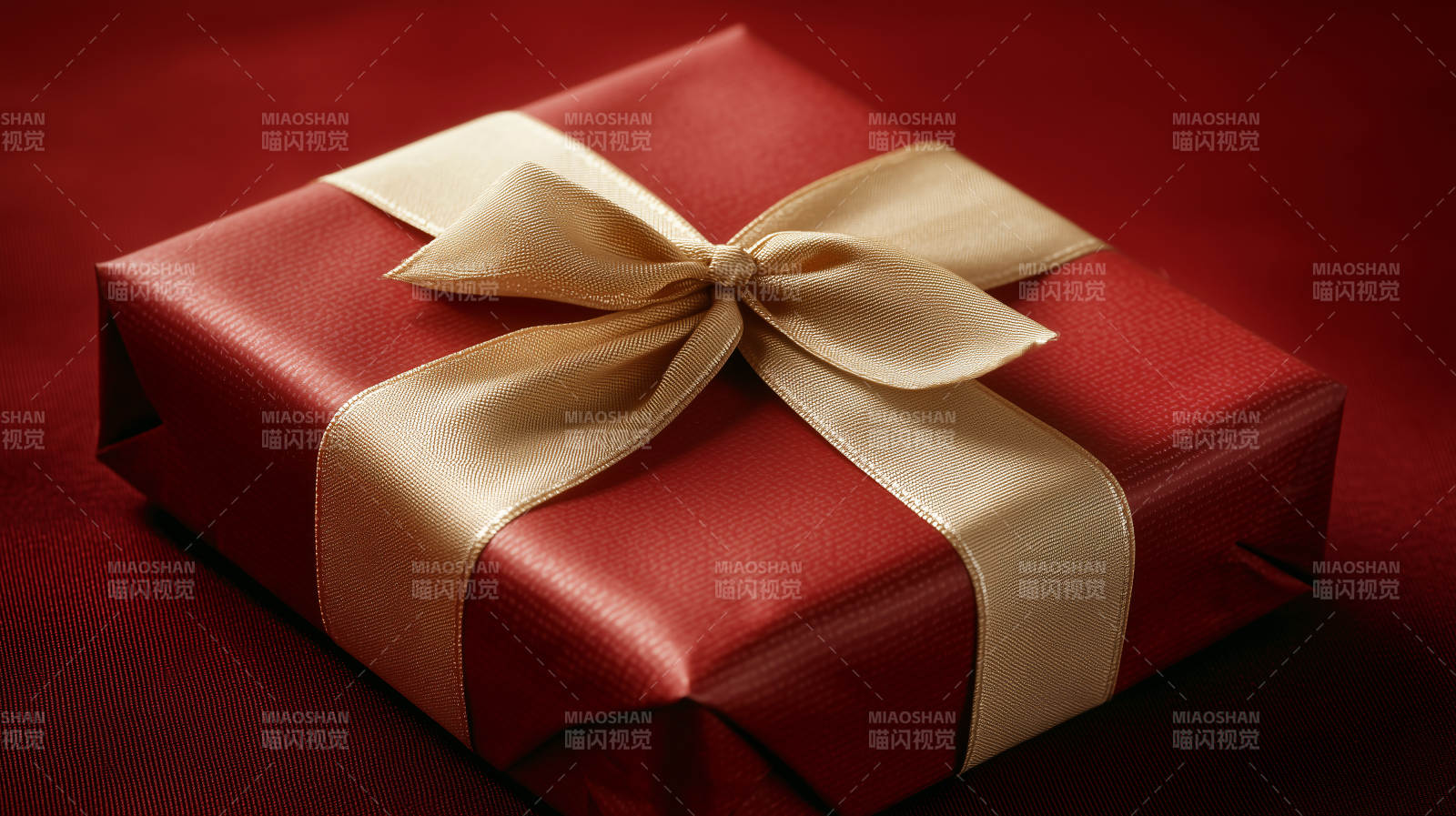深红色礼盒上的金色丝带图片