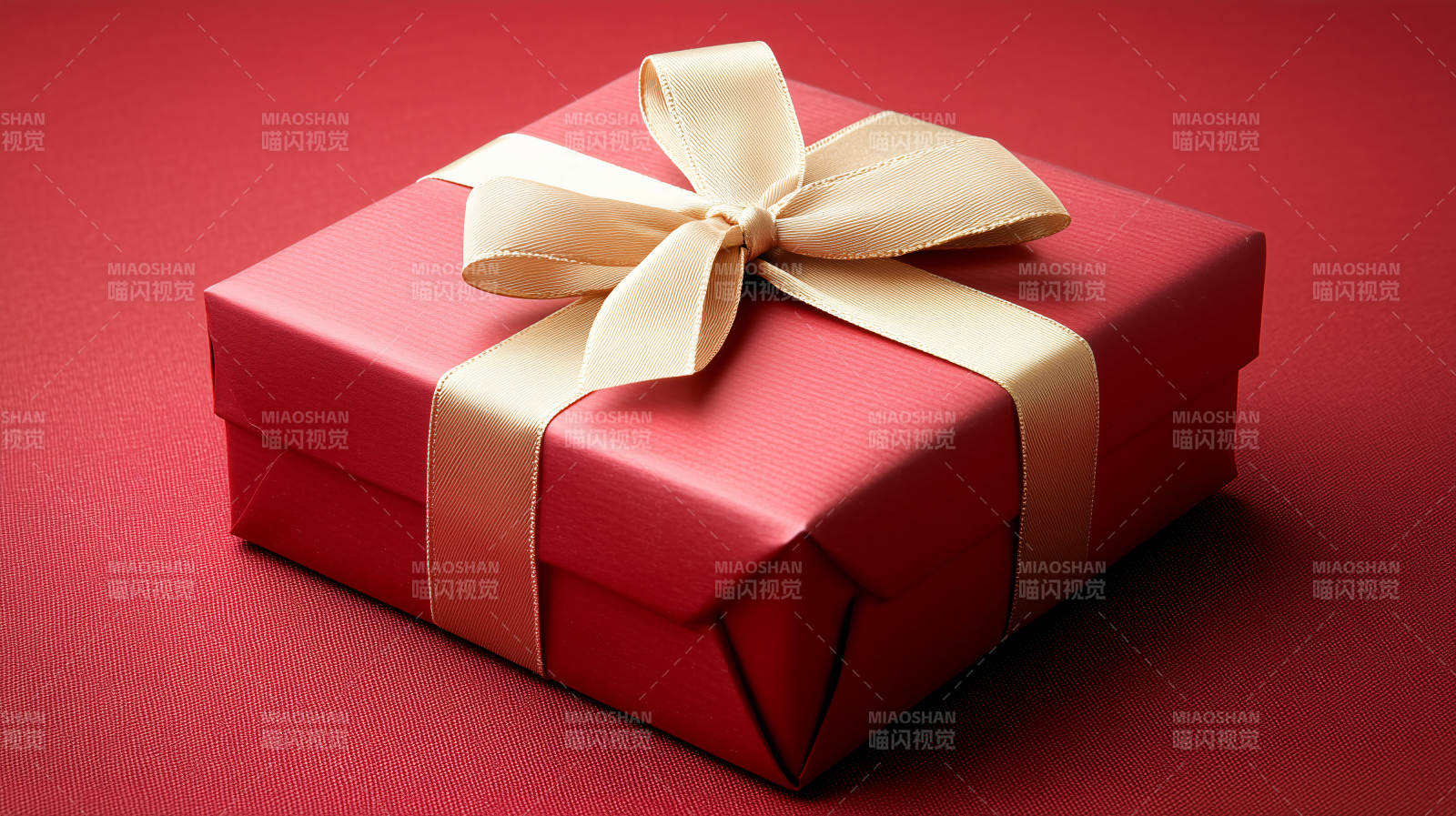 深红色礼盒上的金色丝带图片