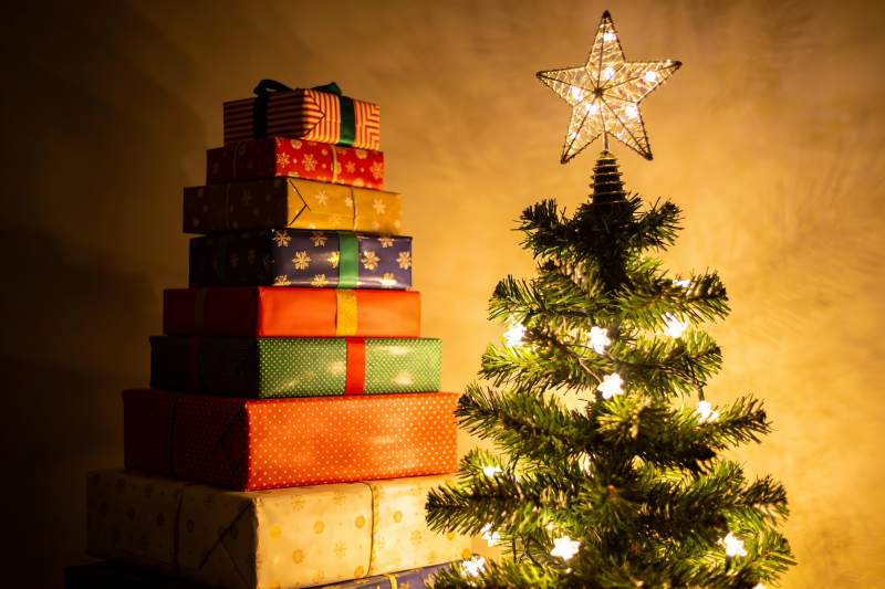 圣诞树旁堆叠的礼物盒图片