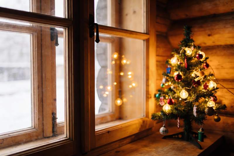 木屋窗边圣诞树温馨夜景图片