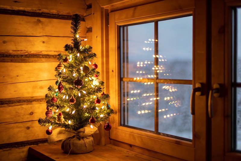 温暖木屋圣诞树窗外雪景图片