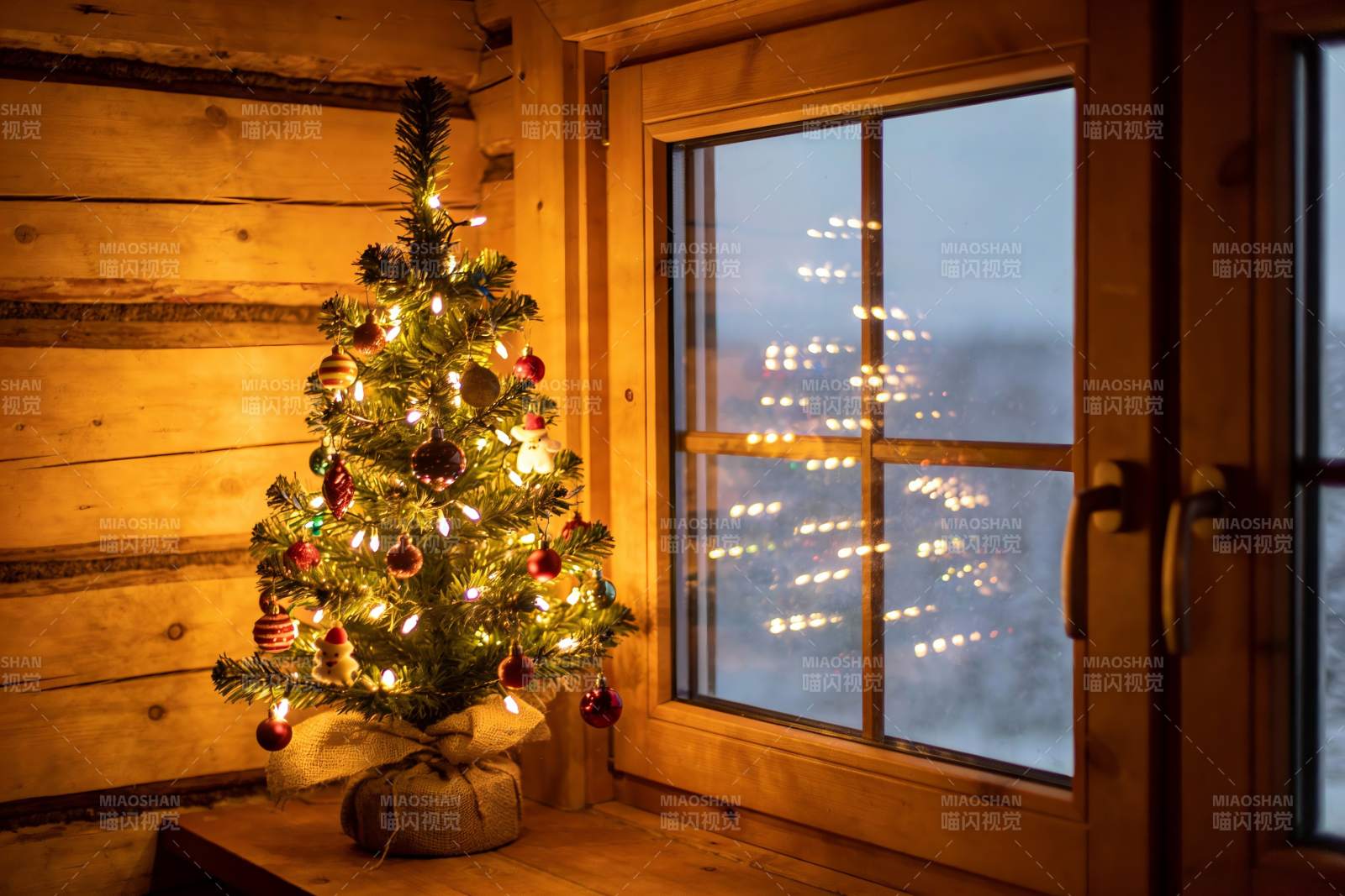 温暖木屋圣诞树窗外雪景图片
