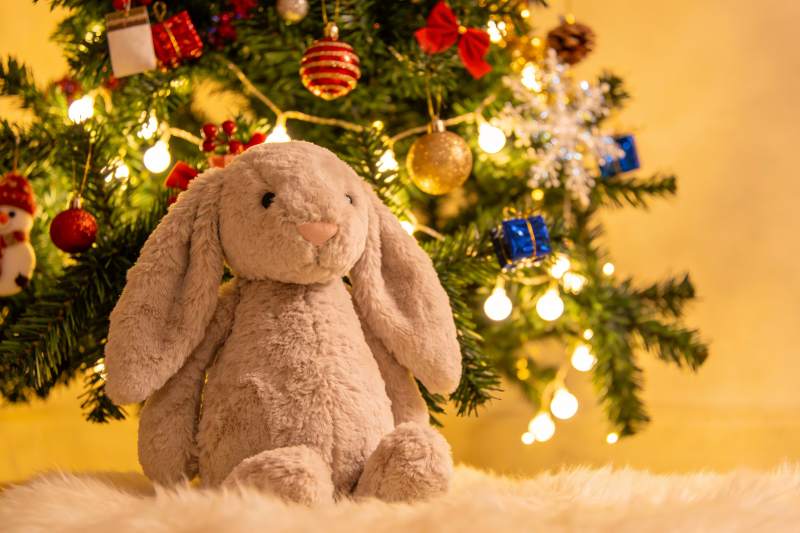 圣诞树前的毛绒兔子玩偶图片