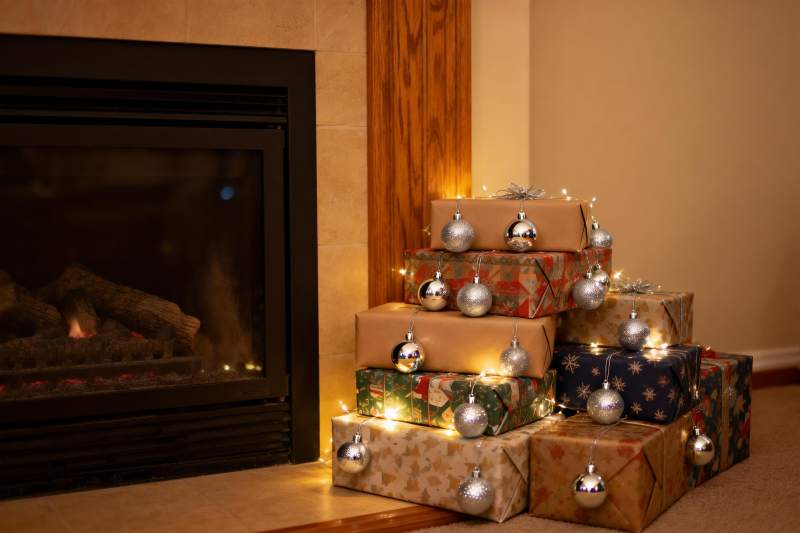 壁炉旁圣诞礼物堆叠温馨场景图片