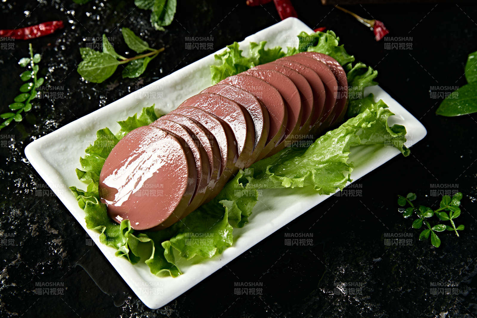 白色瓷盘装的火锅食材鸭血切片图片