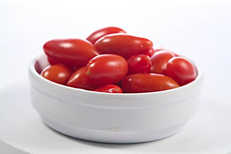 白色背景上摆放的鲜红圣女果图片