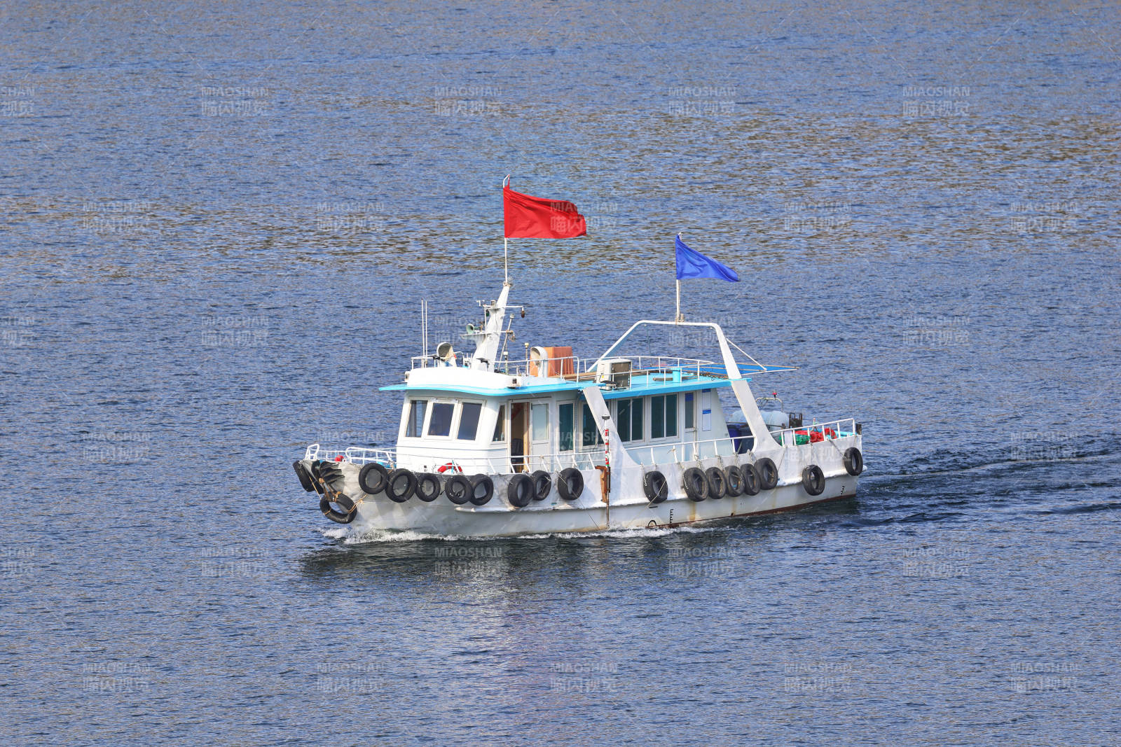 一艘游船在碧蓝的湖面上行驶图片