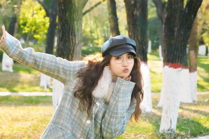 阳光明媚的午后在公园拍照的亚洲美女图片