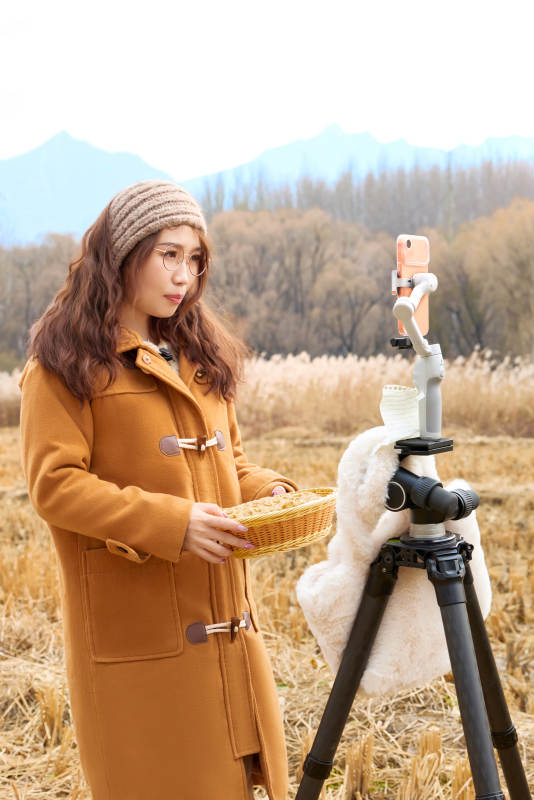 深秋季节在户外进行直播带货的亚洲女性图片