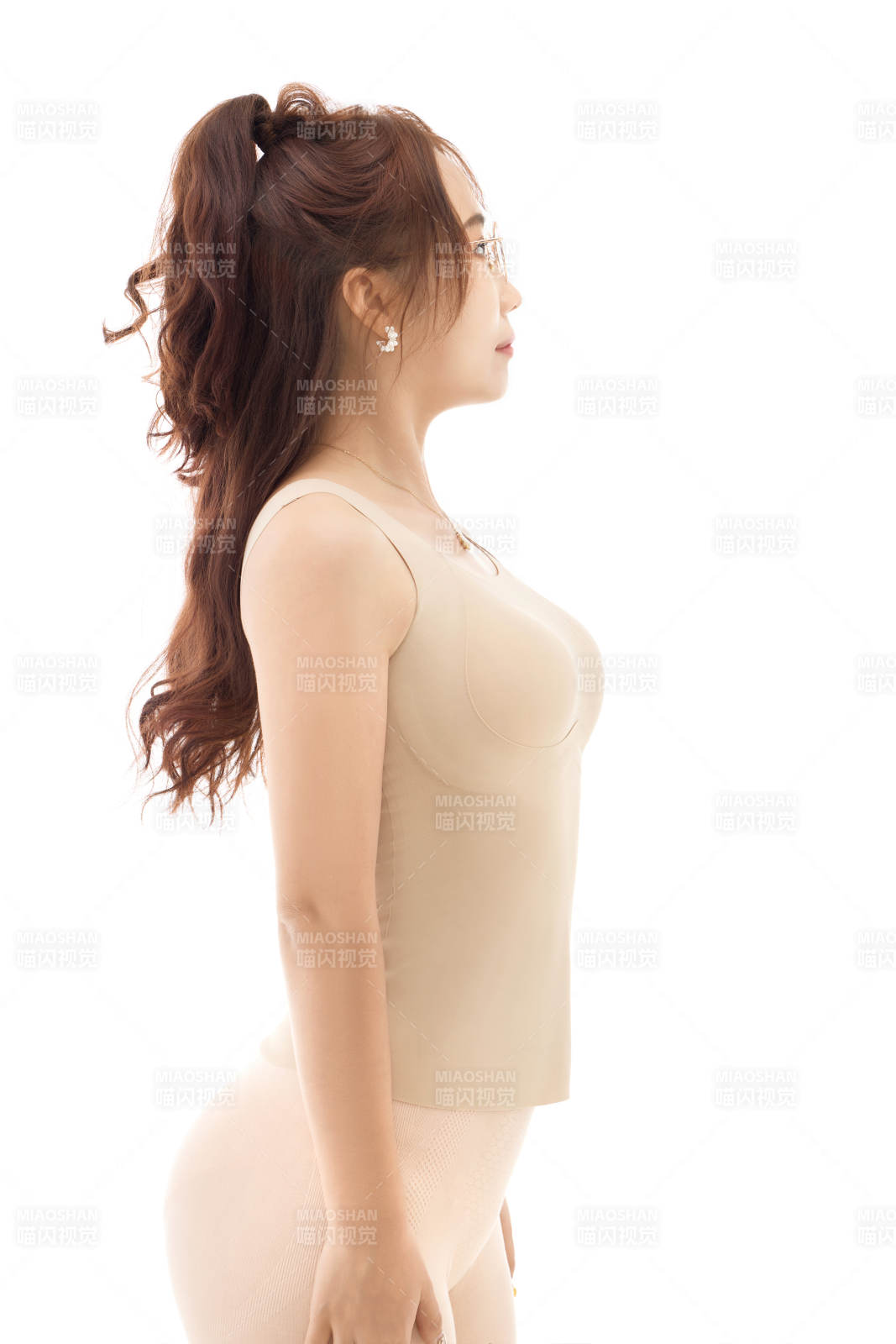 影棚拍摄白色背景前展示女性束身衣的亚洲美女图片