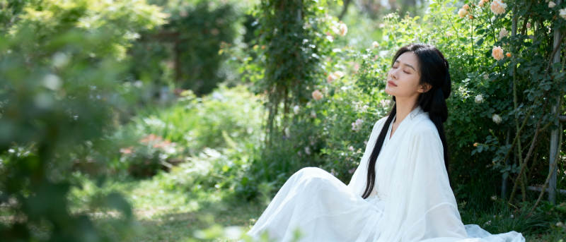 白衣女子静坐花园图片