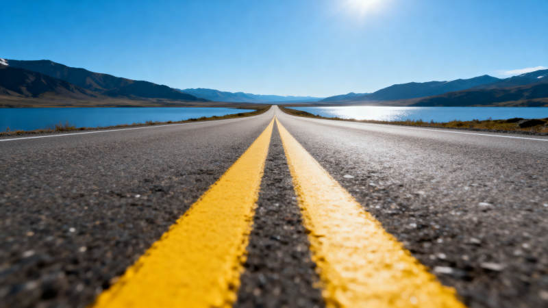 阳光下的公路延伸向远方图片