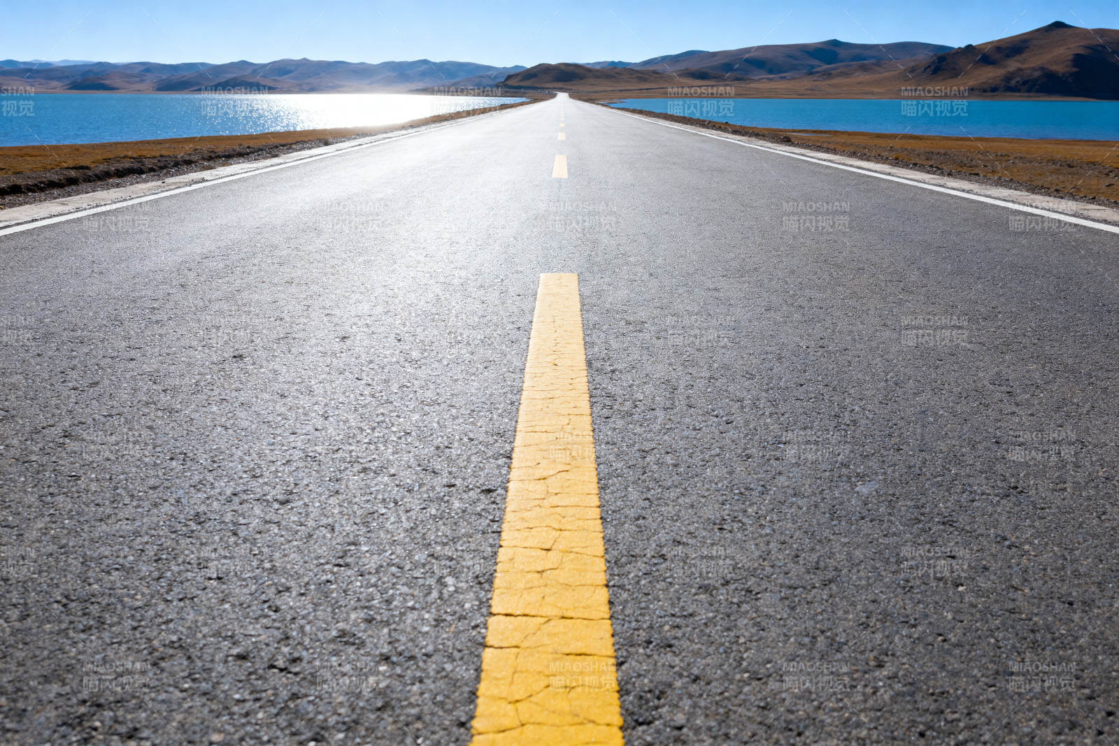公路延伸向远方的湖泊图片