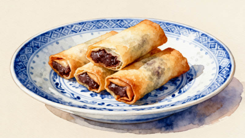 蓝白瓷盘上的豆沙春卷图片
