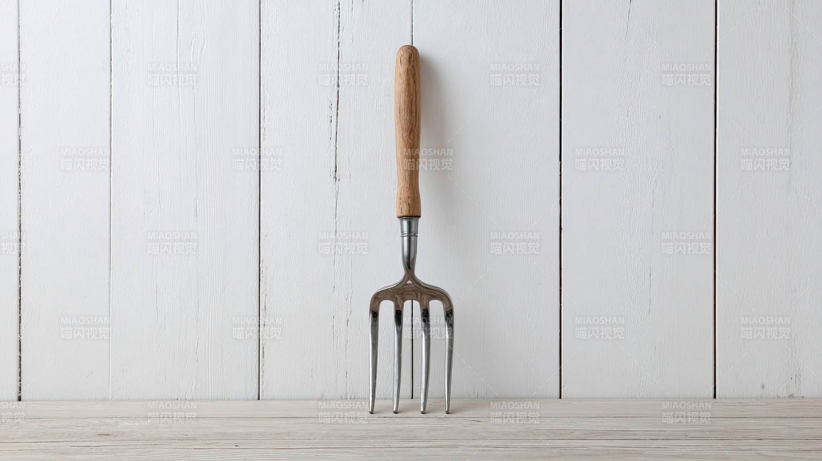 园艺叉静置于木质背景前图片
