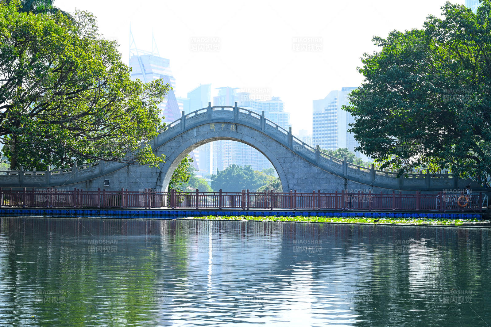 湖上拱桥映绿树图片