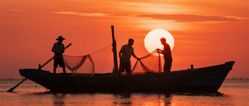 夕阳下的渔船剪影图片