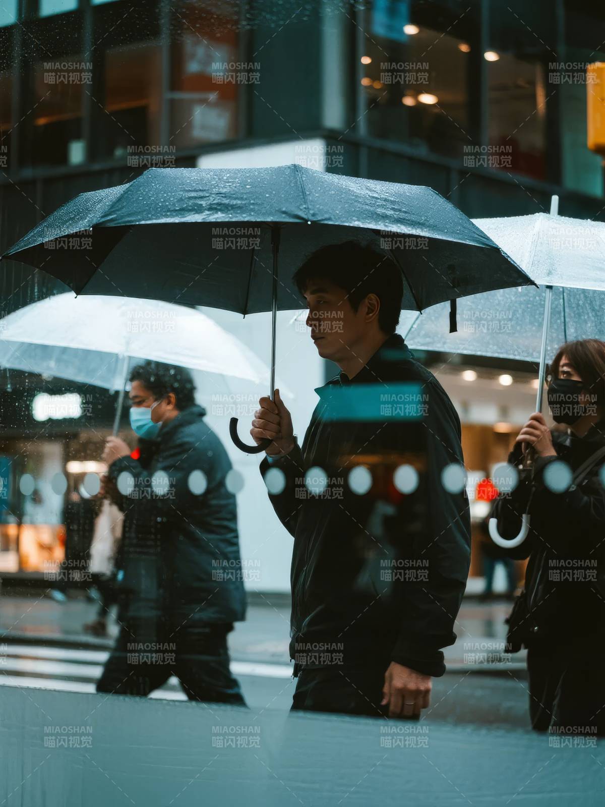 雨中行人撑伞前行图片