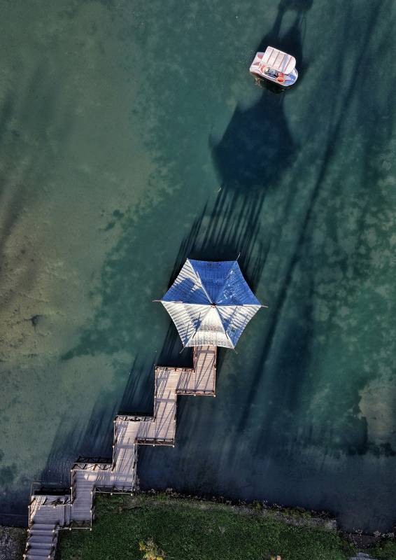 湖上伞影小船行图片