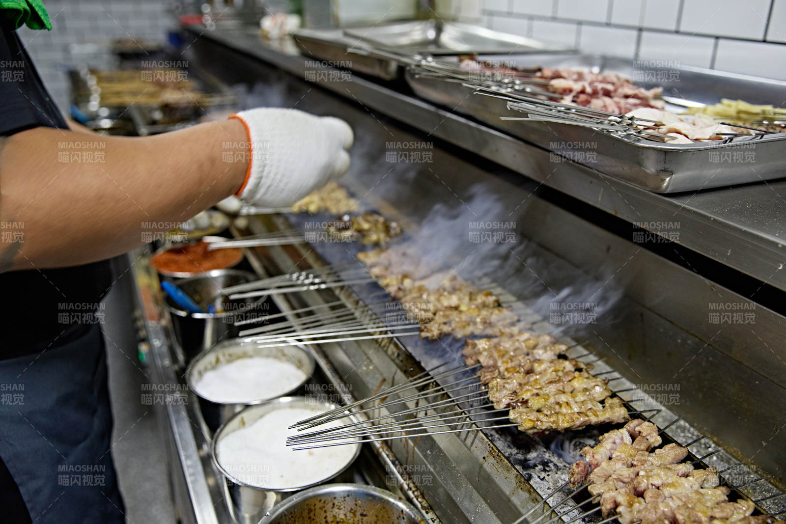 烧烤店后厨的厨师在烤炉上的烤制美食肉串图片