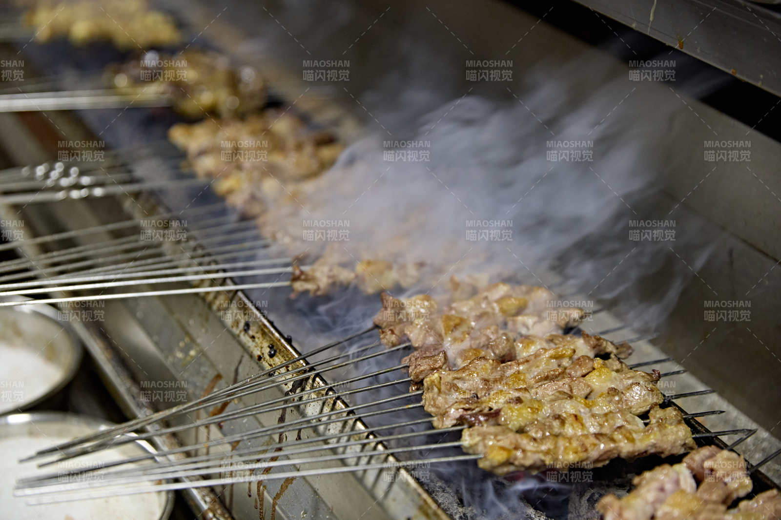 烧烤店后厨的厨师在烤炉上的烤制美食肉串图片