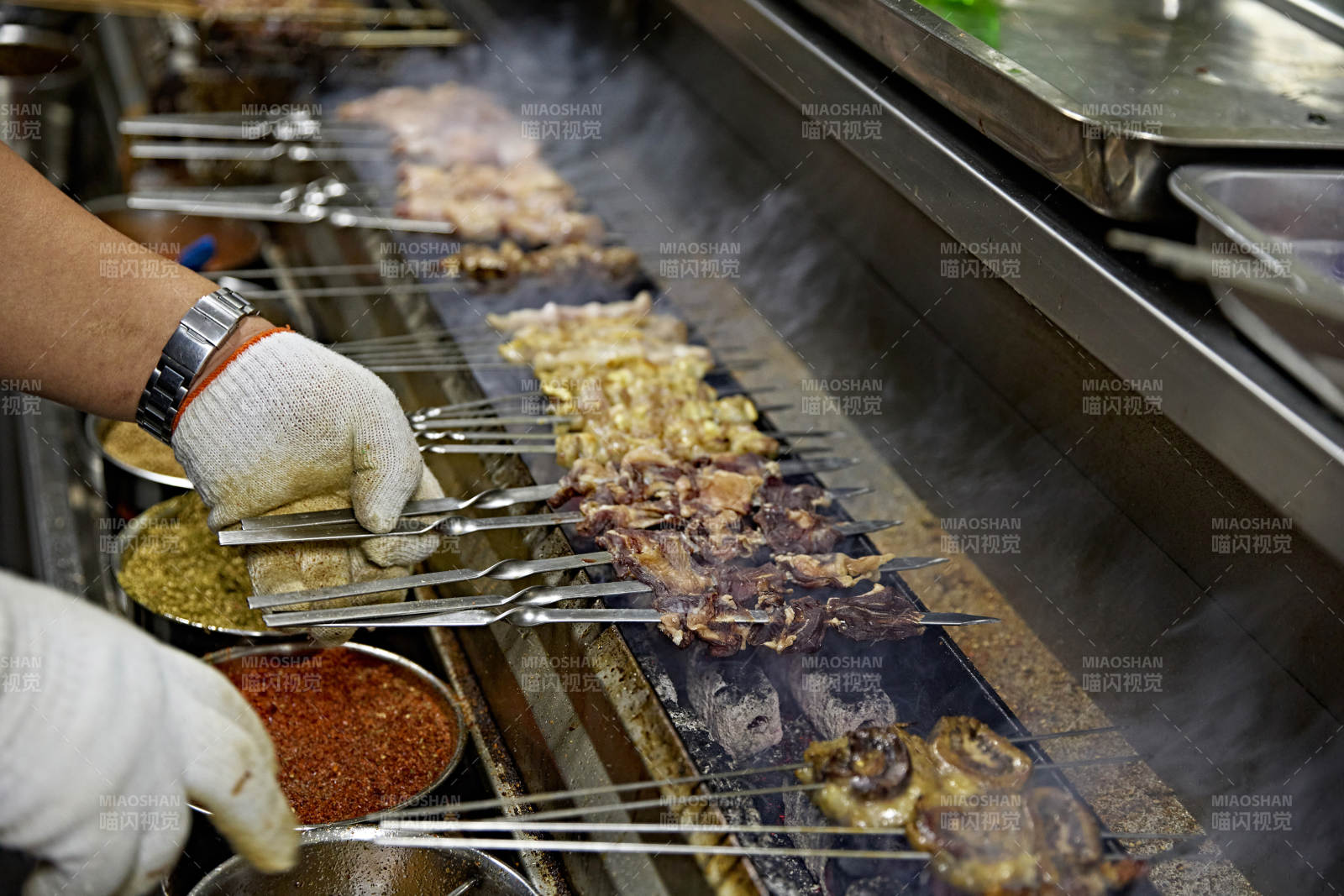 烧烤店后厨的厨师在烤炉上的烤制美食肉串图片