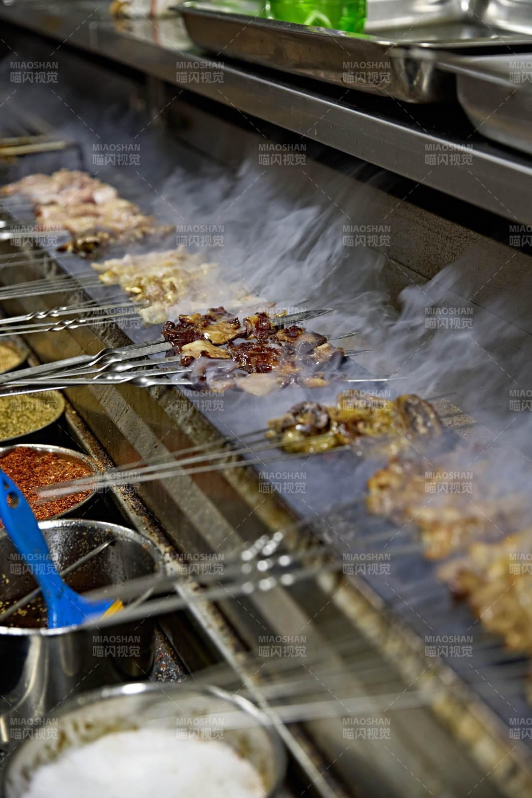 烧烤店后厨的厨师在烤炉上的烤制美食肉串图片