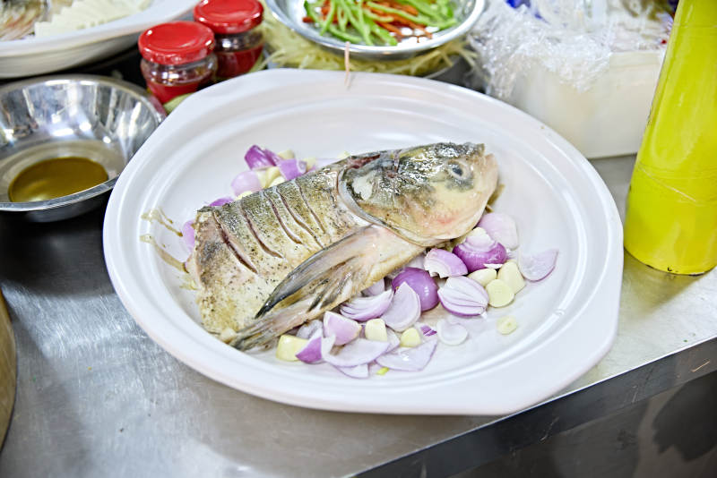 餐饮后厨正在制作中的砂锅鱼头半成品图片
