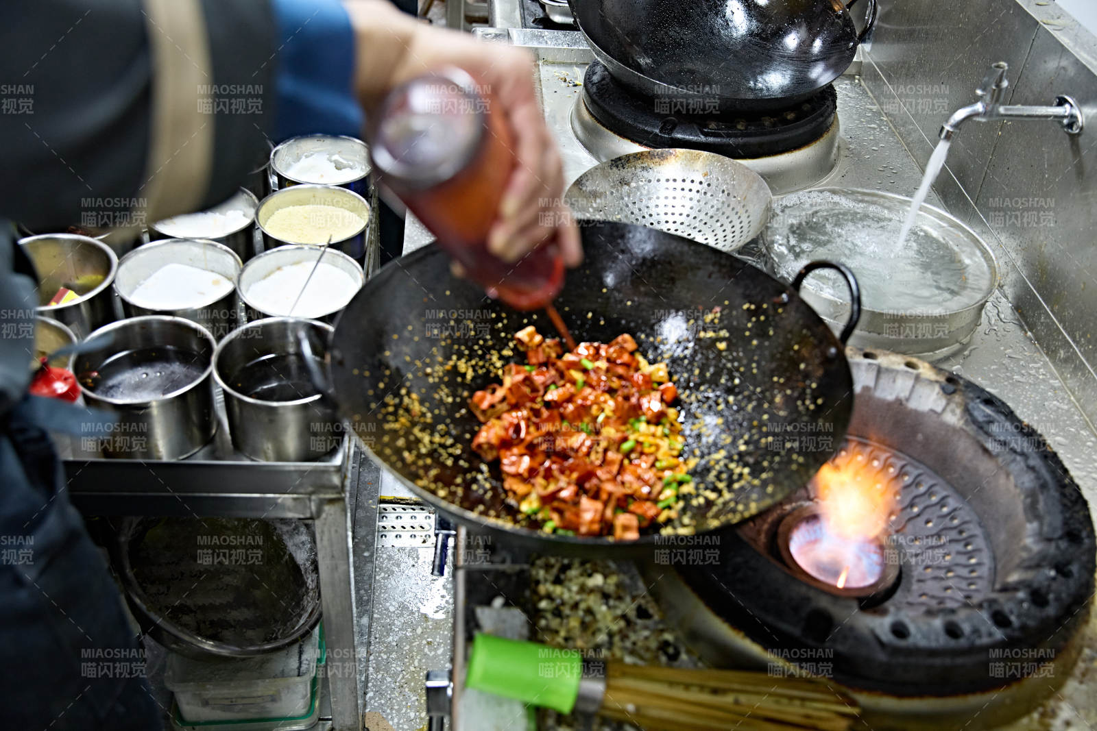 人与食物紧张忙碌的中餐厨房炒制辣子鸡丁图片