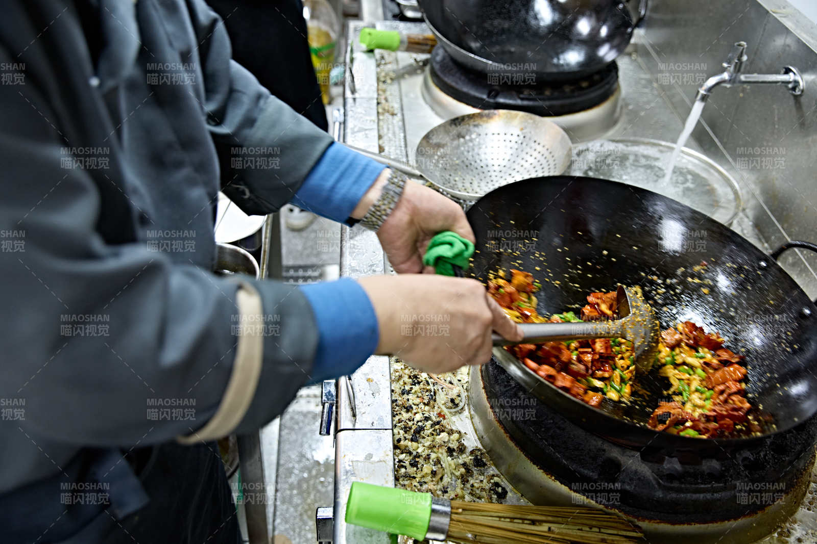 人与食物紧张忙碌的中餐厨房炒制辣子鸡丁图片