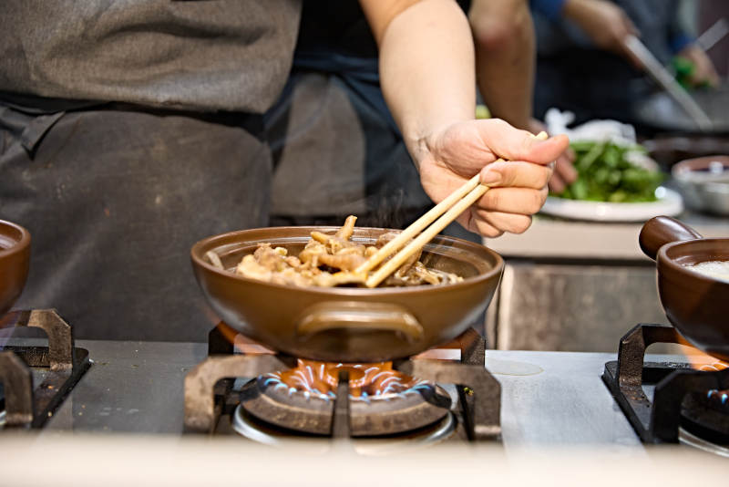 人与食物紧张忙碌的中餐厨房炒制辣子鸡丁图片