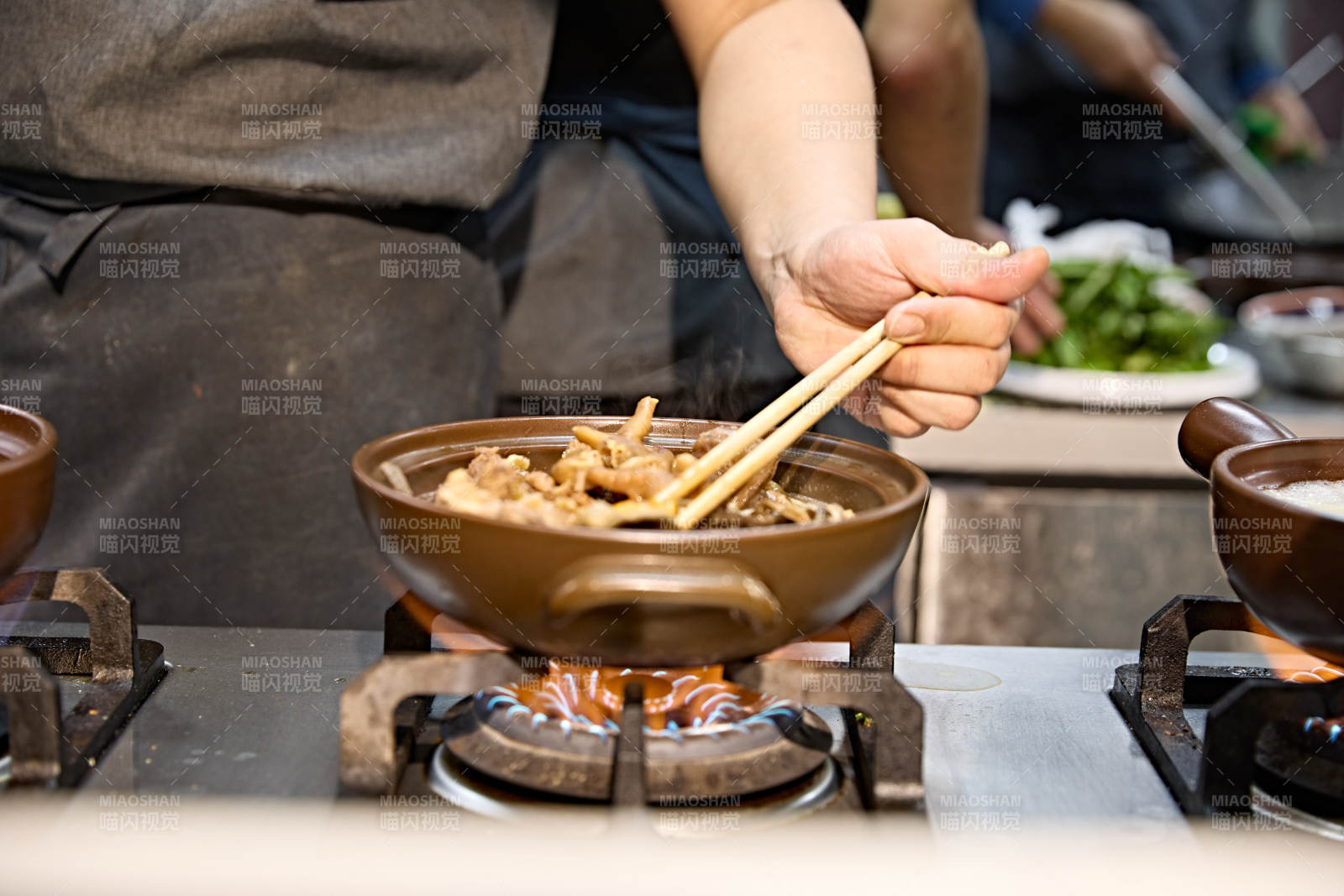 人与食物紧张忙碌的中餐厨房炒制辣子鸡丁图片