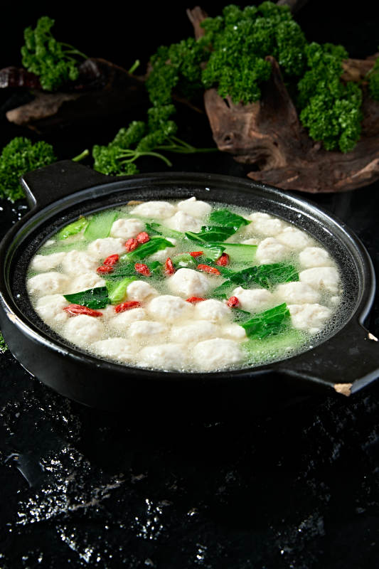 黑色砂锅炖煮的枸杞浓汤手打鱼丸图片