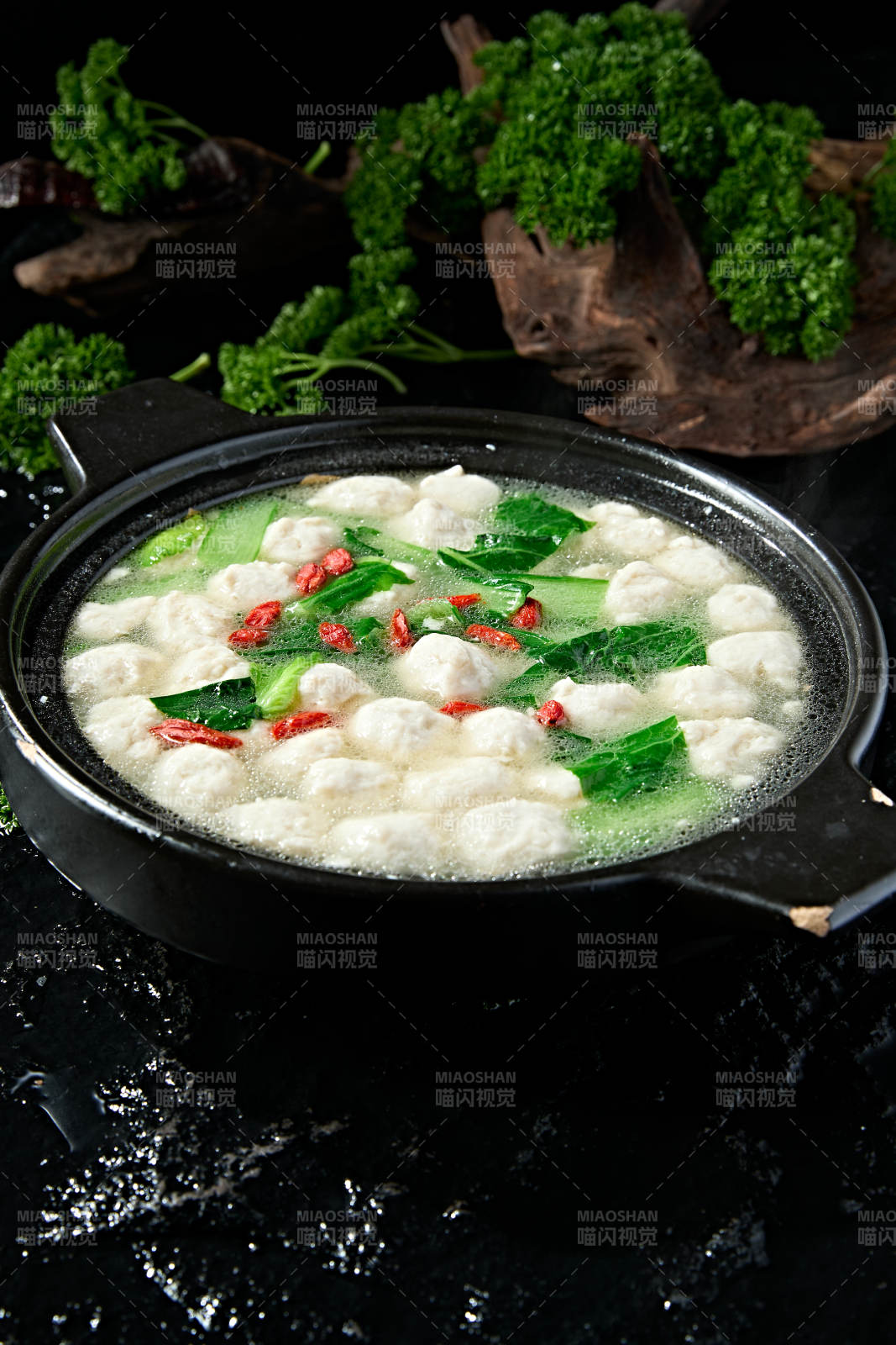 黑色砂锅炖煮的枸杞浓汤手打鱼丸图片