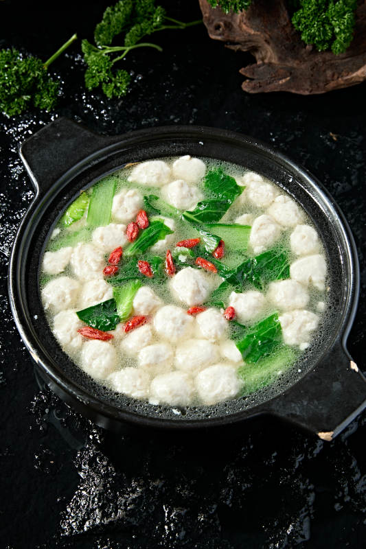 黑色砂锅炖煮的枸杞浓汤手打鱼丸图片