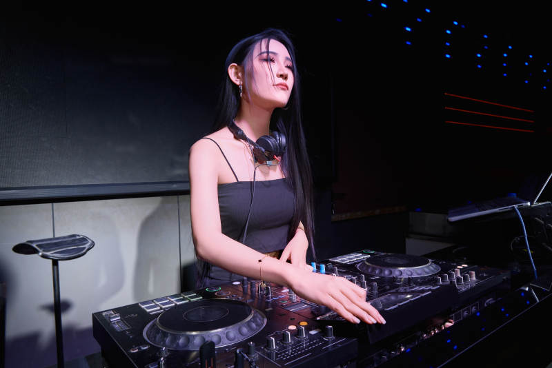 穿着性感黑色吊带裙的女DJ在打碟图片