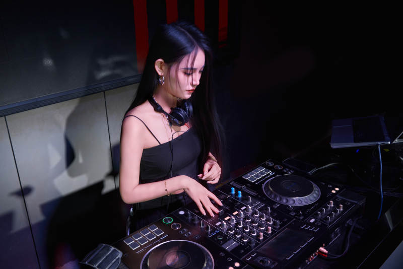 穿着性感黑色吊带裙的女DJ在打碟图片