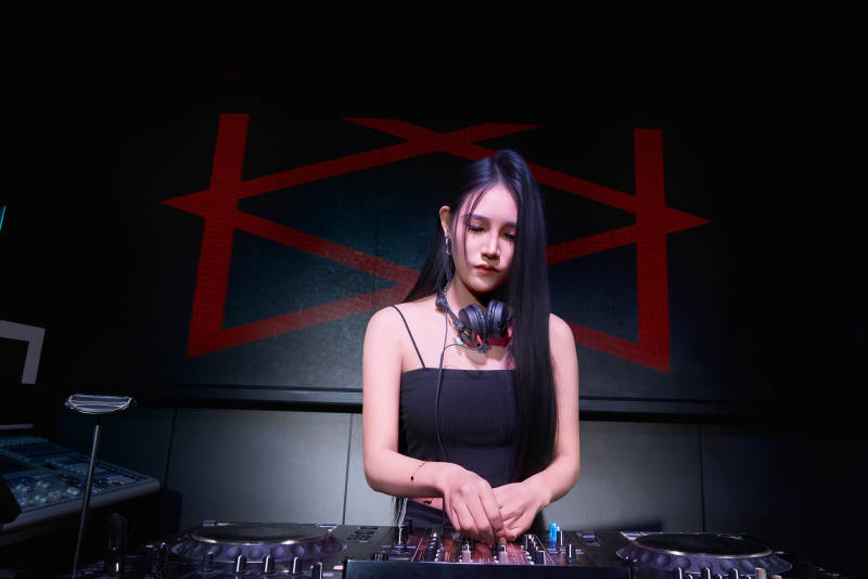 穿着性感黑色吊带裙的女DJ在打碟图片