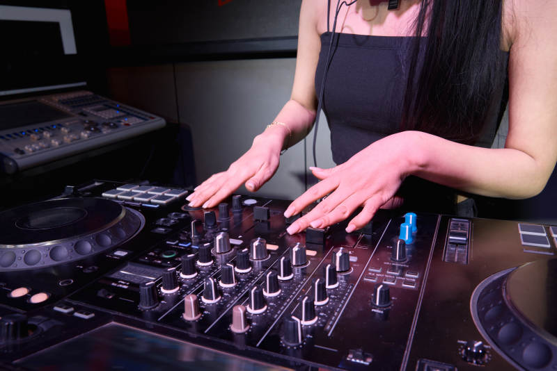 穿着性感黑色吊带裙的女DJ在打碟图片