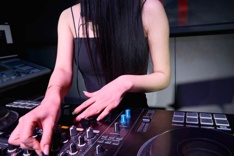 穿着性感黑色吊带裙的女DJ在打碟图片