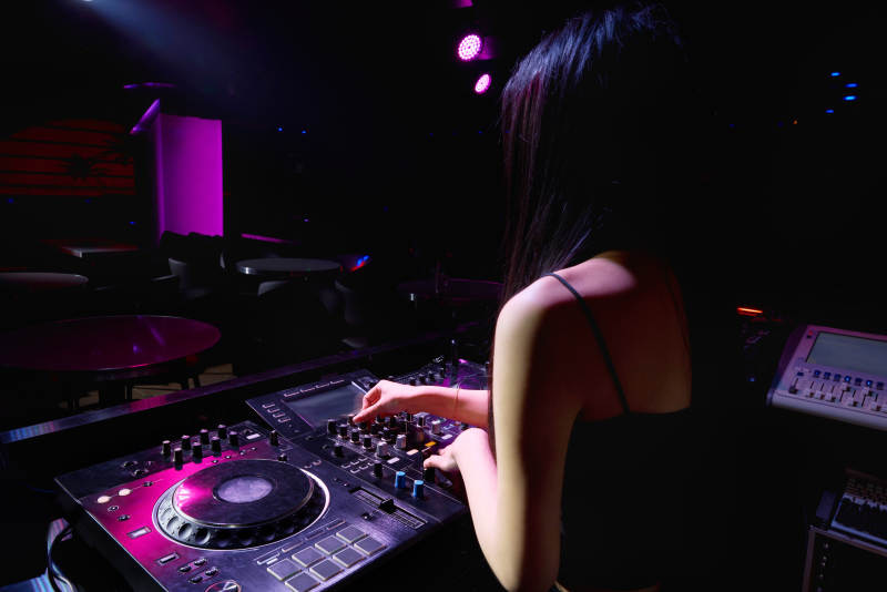 穿着性感黑色吊带裙的女DJ在打碟图片