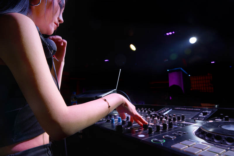 穿着性感黑色吊带裙的女DJ在打碟图片