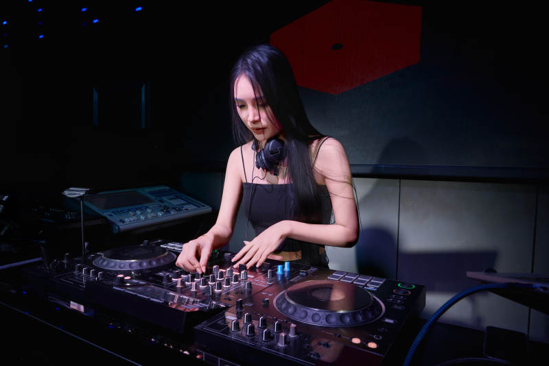 穿着性感黑色吊带裙的女DJ在打碟图片
