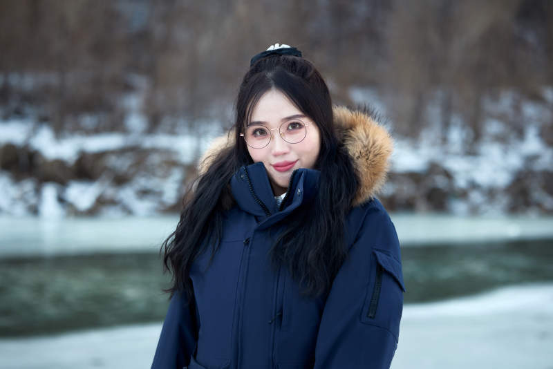 在野外雪地欣赏雪景游玩拍照的亚洲女性图片