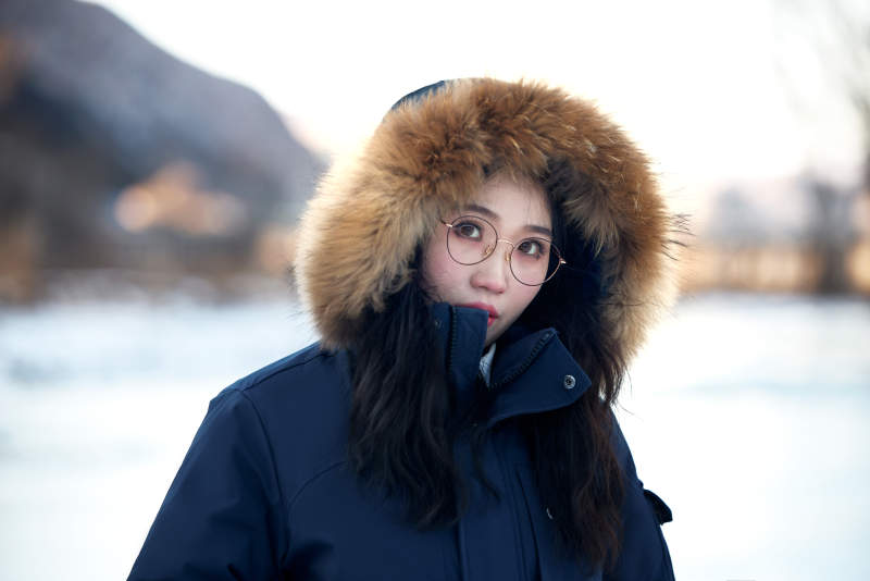 在野外雪地欣赏雪景游玩拍照的亚洲女性图片