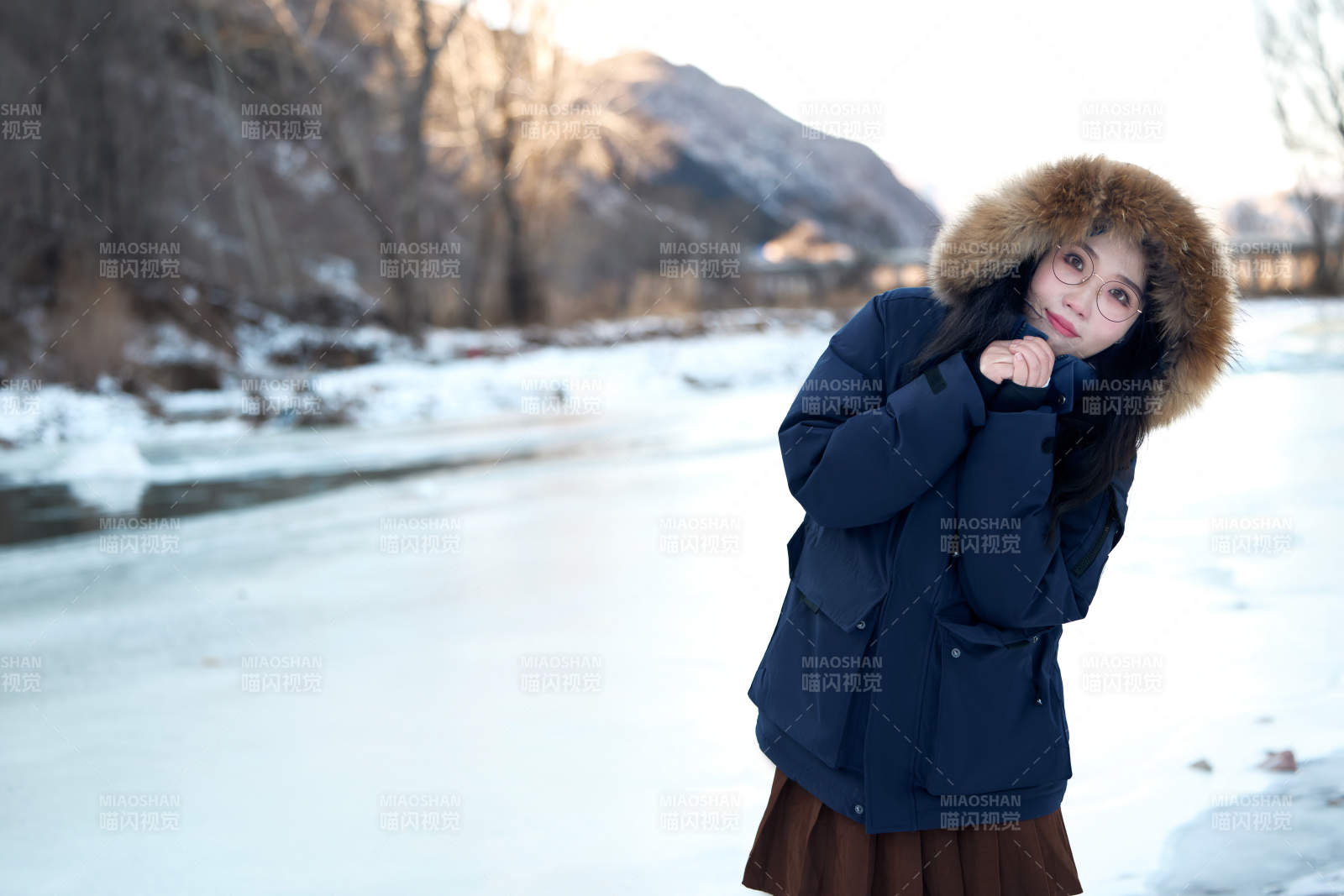 在野外雪地欣赏雪景游玩拍照的亚洲女性图片